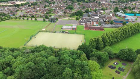 Toma-Aérea-En-Movimiento-Que-Captura-Un-Campo-De-Fútbol-En-La-Ciudad-De-East-Sussex-En-Inglaterra-Con-Un-Hermoso-Paisaje-Urbano-Al-Fondo