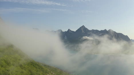 Drone-view,-flying-through-clouds-in-beautiful-mountain-landscape,-Lofoten-Islands,-Norway