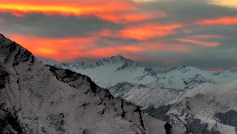 Wunderschöne-Malerische-Luftaufnahme-Des-Sonnenuntergangs-über-Hohen-Schneebedeckten-Bergen