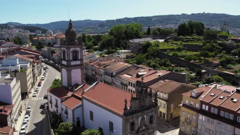 Aerial-view-of-Igreja-de-São-Vicente,-showcasing-its-historic-architecture-amid-Braga's-vibrant-urban-landscape