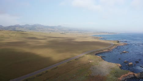 Wide-aerial-panning-shot-of-Hearst-Ranch-and-surrounding-coastal-land-near-the-Northern-Elephant-Seal-Rookery-in-San-Simeon,-California