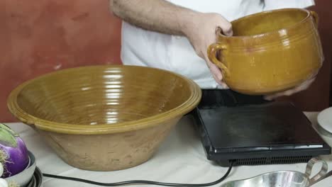 Close-up-kitchen-shot-cook-with-ceramic-brown-pots-eggplants-vintage-chef-style