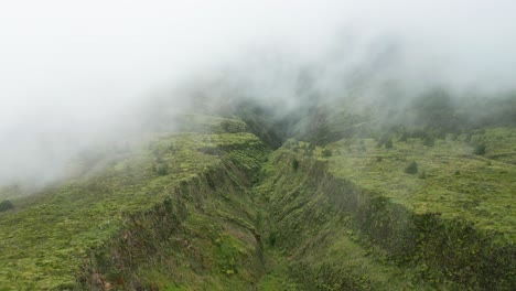 Misty-green-hills-and-valleys-in-lagoa-do-fogo,-aerial-view