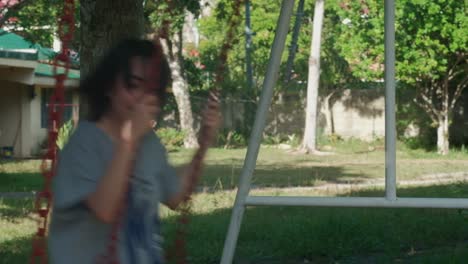 Lone-Young-Woman-Swinging-At-The-Park-During-Sunny-Day