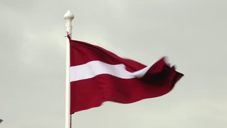 Latvian-flag-flutters-proudly-in-the-wind-against-a-clear-sky