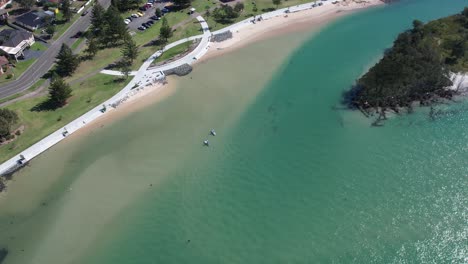 Panoramic-aerial-establishing-orbit-of-sandy-beach-and-promenade-walking-path-in-Windang-NSW-Australia