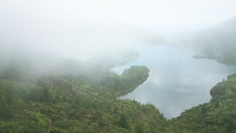 Foggy-view-of-Lagoa-do-Fogo-lake-and-lush-green-hills-shrouded-in-mist