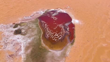 Top-down-aerial-view-of-the-vibrant-scarlet-waters-of-Wulan-Lake-in-the-Tengger-Desert,-Inner-Mongolia-Autonomous-Region,-China