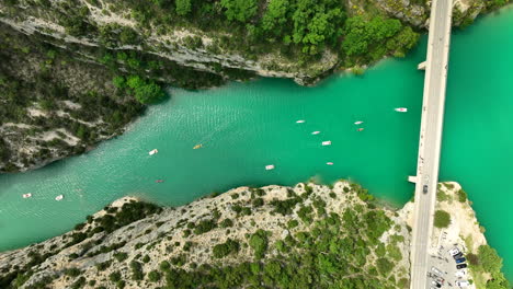 Aerial-birdseye-following-flow-of-river-in-Verdon-Gorge,-boats-sailing