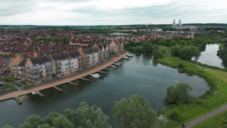 Aerial-pan-shot-of-luxury-apartments-situated-beside-a-lake-with-yachts-halted-in-Est-Sussex,-England