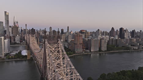 NYC-New-York-Luftaufnahme-V362-Panorama-Überführung-über-Die-Queensboro-Bridge-Mit-Roosevelt-Island,-East-River,-Stadtbild-Von-Manhattan-Und-Queens-Borough-Im-Morgengrauen-–-Aufgenommen-Mit-Mavic-3-Pro-Cine-–-September-2023