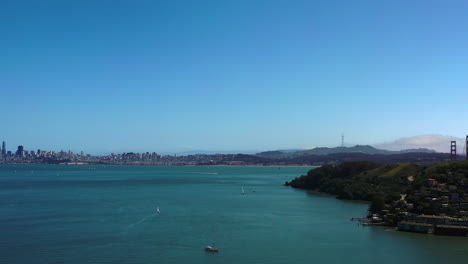 Aerial-view-backwards-over-the-coastline-of-Sausalito,-in-sunny-California,-USA