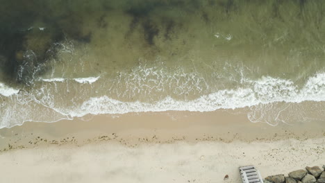 Waves-Crashing-On-Sandy-Shore-At-Sunset