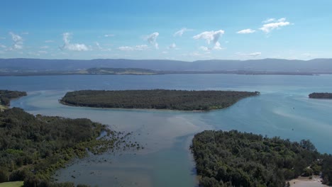 Windang-Lake-estuary-and-coastal-forest-with-shallow-sandy-waters,-panoramic-aerial-establishing