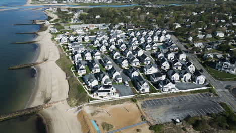 Vista-Aérea-Del-Pintoresco-Barrio-Suburbano-Costero-Lleno-De-Casas-Residenciales-Grises-A-Lo-Largo-Del-Puerto-De-Dennis,-Cape-Cod,-Massachusetts-Durante-El-Día