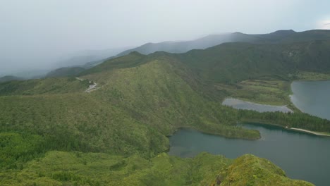 Scenic-aerial-view-of-Lagoa-do-Fogo's-lush-green-mountains-and-tranquil-blue-waters-in-the-Azores