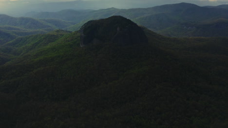 Aerial-panning-to-reveal-Looking-Glass-Rock-towering-over-Asheville-NC-forest