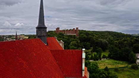 Iglesia-De-La-Asunción-Con-El-Palacio-De-Marianna-Orańska-Al-Fondo-En-Kamieniec-Ząbkowicki,-Polonia