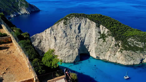 Ein-Mann-Und-Eine-Frau-Am-Navagio-Strand-Mit-Aussicht-Auf-Der-Insel-Zakynthos,-Griechenland---Luftaufnahme