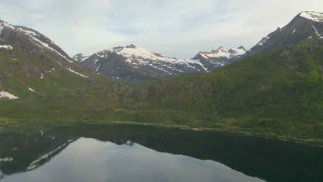 Snow-covered-mountain-reflected-in-lake,-Lofoten,-Northern-Norway