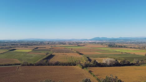 Una-Impresionante-Vista-Aérea-De-Un-Dron-Volando-Sobre-Impresionantes-Campos-Con-Montañas-Distantes-Al-Fondo