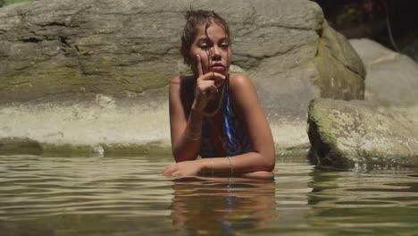 En-La-Isla-Tropical-De-Trinidad,-Una-Joven-En-Bikini-Disfruta-De-La-Cascada-Y-El-Río.