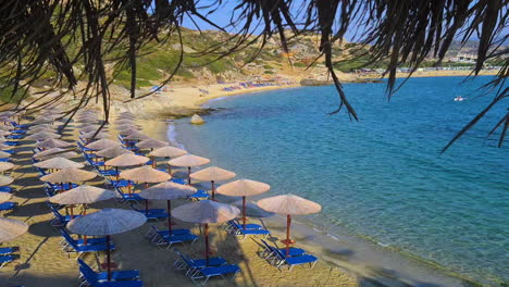 Empty-Beach-on-Mediterranean-Sea,-Sunshades-and-Parasols-on-Sunny-Morning