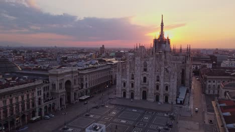 Un-Ascenso-Con-Drones-Con-Perspectiva-Frontal-De-La-Catedral-De-Milán-En-La-Región-De-Lombardía,-Italia,-Filmado-Durante-El-Amanecer-Y-Con-Los-Rayos-Del-Sol-Asomando-Detrás-Del-Edificio.