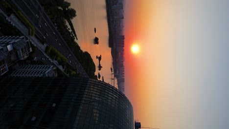 Vertical-aerial-establishing-shot-of-Linyi-City-with-the-Binhe-River-in-the-Shandong-Province-during-sunset