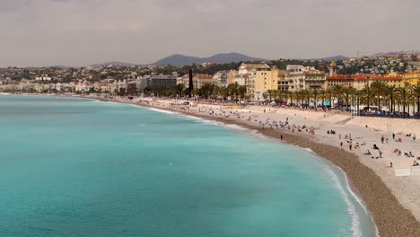 People-enjoy-beach-along-beautiful-Promenade-des-Anglais-in-Nice,-France