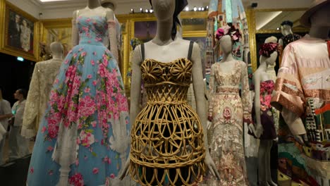 Mannequins-dressed-in-vintage-fashion-displayed-in-an-ornate,-art-filled-museum-setting