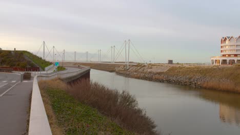 Modern-bridge-"La-Passerelle-du-Grand-Large"-spans-a-tranquil-canal-in-Dunkerque,-France