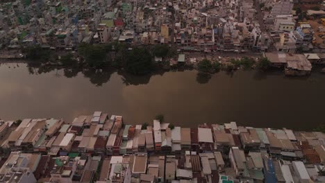 Urban-density-along-canal-in-poor-area-of-Ho-Chi-Minh-City,-Vietnam-showing-rooftops-in-late-afternoon-light