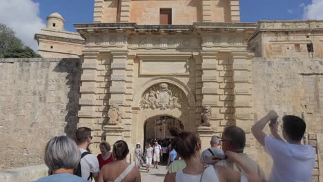 Los-Turistas-Pasan-Por-El-Portal-Barroco-De-La-Puerta-De-Mdina,-También-Llamada-Puerta-Principal-O-Puerta-De-Vilhena,-La-Entrada-Principal-A-La-Ciudad-Fortificada-De-Mdina,-Malta.