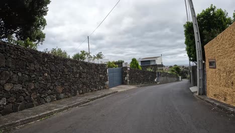 White-van-turning-at-a-street-corner-with-a-stop-sign-on-Sao-Miguel-Island,-Azores