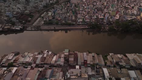 Urban-density-along-canal-in-poor-area-of-Ho-Chi-Minh-City,-Vietnam-showing-rooftops-in-late-afternoon-light