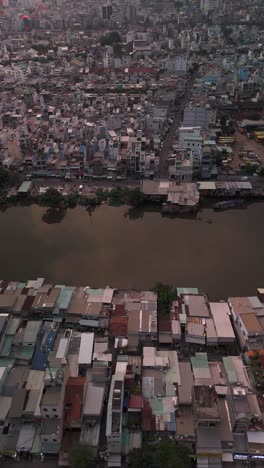 Urban-density-along-canal-in-poor-area-of-Ho-Chi-Minh-City,-Vietnam-showing-rooftops-in-late-afternoon-light