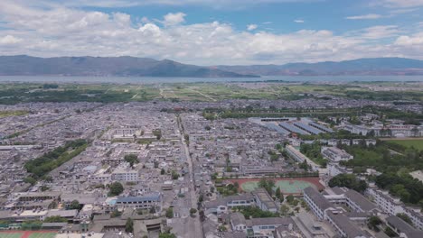 Imágenes-De-Drones-Con-Panorámica-Horizontal-De-La-Principal-Calle-Peatonal-De-La-Antigua-Ciudad-De-Dali,-Con-El-Magnífico-Er-Hai-Y-Las-Montañas-De-Fondo