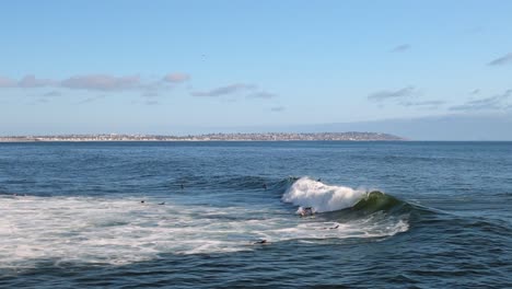 Surfers-And-Waves-Crawling-On-White-Foamy-Surface-On-The-Pacific-Ocean-In-San-Diego,-California,-USA