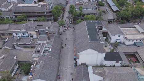 Drone-footage-of-visitors-exploring-Dali's-Ancient-City-located-in-Yunnan-Province,-China