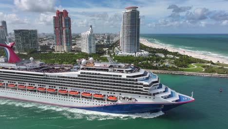 Carnival-cruise-ship-leaving-Port-of-Miami-past-South-Pointe-Park,-Miami-Beach