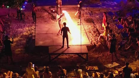 Tourists-Crowd-on-Beach-Party-Watching-and-Participating-on-Jumping-Fire-Rope,-Thailand