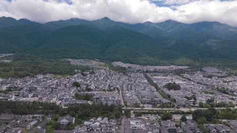 Magnificent-aerial-footage-showcasing-the-beauty-of-the-Cang-Shan-Mountains,-with-Dali's-Ancient-City-at-its-foot