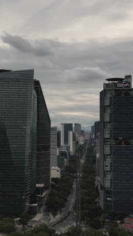 Aerial-view-between-the-buildings-on-Paseo-de-la-Reforma,-vertical-mode