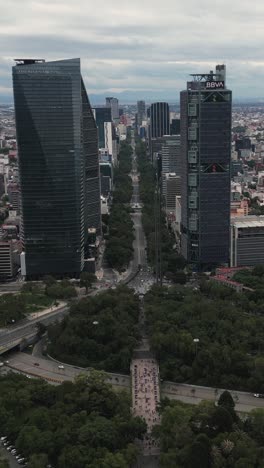 Paisaje-Urbano-Capturado-Por-Drones-Del-Paseo-De-La-Reforma-En-Medio-De-Edificios-Modernos,-Modo-Vertical