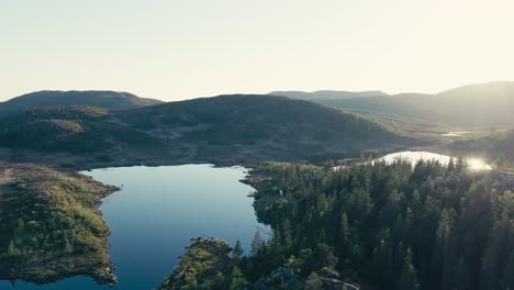 Mjøvatnet,-Indre-Fosen,-Trøndelag,-Norway---An-Early-Morning-Scene-of-a-Lake-Encircled-by-a-Rugged-Landscape-With-Forested-Hills---Aerial-Drone-Shot