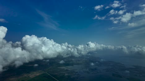 POV-flying-over-lagoons-of-Venice-city,-Italy,-with-a-deep-blue-sky-and-some-clouds