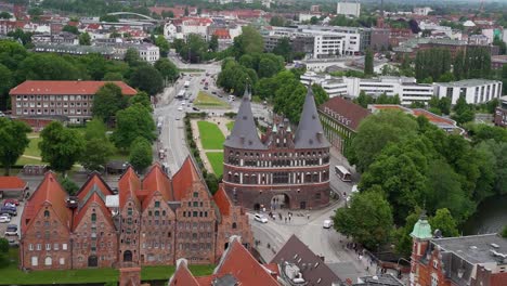 La-Famosa-Puerta-De-La-Ciudad-De-Holstentor,-En-Lübeck,-Está-Bordeada-Por-El-Tráfico-Rodado