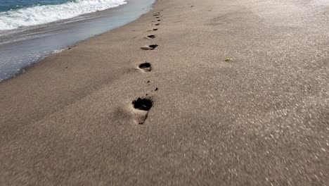 A-video-showcasing-footprints-in-the-sand-on-a-beautiful-sunny-day-at-the-beach