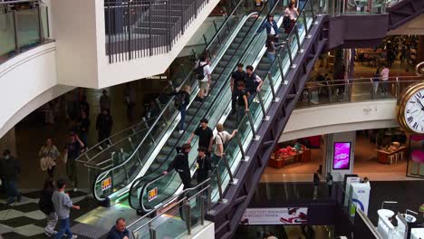 People-taking-the-escalators-up-and-down-during-rush-hours-at-Melbourne-Central-Station,-a-shopping-and-commercial-precinct-in-downtown-area,-showcasing-the-hustle-and-bustle-lifestyle